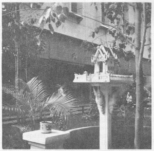 An elaborate spirit house in the garden   of a Saigon Buddhist temple