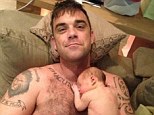 Daddy's little angel: Robbie reveals he has high hopes for his newborn daughter Teddy