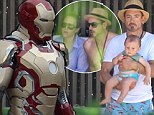 A stark contrast!: Robert Downey Jr. suits up on the Iron Man 3 set after some R&R poolside with the family